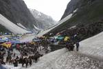 Kashmiri Muslim pony owners wait on the snow for Hindu pilgrims to carry them back to the base camp near Amarnath cave, one of the most revered of Hindu shrines on July 01, 2011. near Baltal, Jammu and Kashmir, India. More than 5,000 Hindu devotees, braving sub-zero temperatures, began the hike over glaciers and along paths overhanging gorges to reach the sacred Amarnath cave housing an ice stalagmite, a stylized phallus worshiped by Hindus as a symbol of the god Shiva, enveloped by the rugged H