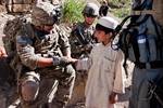 U.S. Army Sgt. Robert Salazar, a team leader in 1st Platoon, A Battery, 2nd Battalion, 377th Parachute Field Artillery Regiment, Task Force 4-25, shakes hands with a local boy in Loy Murghoz, Khowst province, Afghanistan, June 8, 2012.