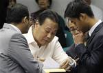 Supreme Court Chief Justice Renato Corona, with a hep-lock attached to his hand, signs a waiver authorizing bank institutions to open his dollar and peso bank accounts during his impeachment trial at the Senate in Manila Friday, May 25, 2012. Corona on Tuesday read a lengthy testimony and 