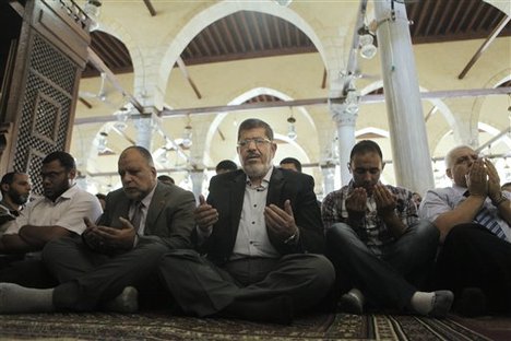 In this Friday, June 22, 2012 file photo, the Muslim Brotherhood's presidential candidate Mohammed Morsi, center, performs Friday prayers in Amr Ibn Al-As mosque in Cairo, Egypt.