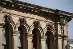 Weathered cornice and decorated keystones in the harbour area of Oamaru, New Zealand