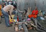 A old Indian Sadhu - Hindu holy man - blesses a pilgrim at a temporary camp in Kolkata, 09 January 2008. Thousands of Hindu pilgrims have started to converge for the Gangasagar Mela which will culminate on 14 January, on the occasion of Makar Sankranti, a holy day of the Hindu calendar, during which a dip in the ocean at the confluence of the River Ganges and the Bay of Bengal, some 150 kms south of Kolkata, is considered to be of great religious significance in Eastern India