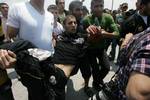 Palestinian protesters carry away a wounded demonsrator after Israeli soldiers opened fire during a massive march towards the Erez border crossing in the northern Gaza Strip on May 15, 2011 to mark the 