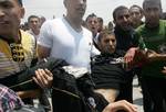 Palestinian protesters carry away a wounded demonsrator after Israeli soldiers opened fire during a massive march towards the Erez border crossing in the northern Gaza Strip on May 15, 2011 to mark the 