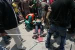 Palestinian protesters carry away a wounded demonsrator after Israeli soldiers opened fire during a massive march towards the Erez border crossing in the northern Gaza Strip on May 15, 2011 to mark the 