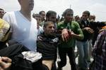 Palestinian protesters carry away a wounded demonsrator after Israeli soldiers opened fire during a massive march towards the Erez border crossing in the northern Gaza Strip on May 15, 2011 to mark the 