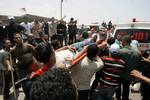 Palestinian protesters carry away a wounded demonsrator after Israeli soldiers opened fire during a massive march towards the Erez border crossing in the northern Gaza Strip on May 15, 2011 to mark the 