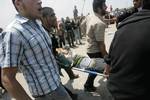 Palestinian protesters carry away a wounded demonsrator after Israeli soldiers opened fire during a massive march towards the Erez border crossing in the northern Gaza Strip on May 15, 2011 to mark the 