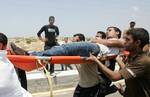 Palestinian protesters carry away a wounded demonsrator after Israeli soldiers opened fire during a massive march towards the Erez border crossing in the northern Gaza Strip on May 15, 2011 to mark the 