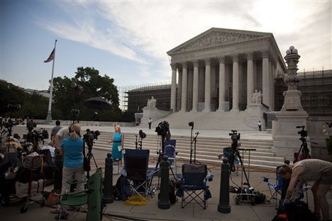 Journalist wait outside the Supreme Court in Washington. Monday, June 25, 2012.