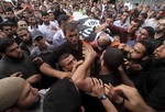 Palestinian mourners carry the body of militant Basil Ahmad during his funeral in Bureij refugee camp, central Gaza Strip, Friday, June 22, 2012.