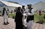 Afghan delegates talk with each other outside the site of the Peace Jirga in Kabul, Afghanistan, Friday, June 4, 2010. Delegates to the Afghan peace conference voiced strong support Friday for negotiations between their government and the Taliban to try to end years of war.