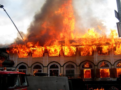 Kashmiri residents help firefighters as a fire rages at the sufi shrine of Sheikh Abdul Qadir Geelani known as Dastageer Sahib in downtown Srinagar on June 25, 2012. A massive fire has broken out in the 200 year old heritage Sufi shrine however, officials said the anciet relics of the saint kept inside a fire-proof safe at the shrine have been saved and retrieved.