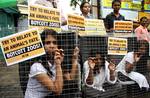 People for the Ethical Treatment of Animals (PETA) activists are pictured inside cages during a protest outside the Alipore Zoological Garden in Kolkata on June 19, 2012. The PETA activists staged the demonstration to protest against the recent death of animals at the zoo