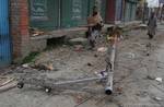 People salvaging an electric pole strong that fell wind lying on street in Srinagar, 20, March, 2012. Strong winds blew away many roofs in Kashmir since Monday evening. Authorities ordered closure of schools on Tuesday across the region. Weathermen said the winds which started Monday evening blew at 60 kmph, and expected to continue till Tuesday late afternoon.