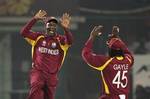 West Indies captain Darren Sammy, left, celebrates with Chris Gayle after catching out South African AB de Villiers during their Cricket World Cup Group B match in New Delhi, India, Thursday, Feb. 24, 2011.