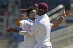 West Indies' bowler Ravi Rampaul, left, celebrates with his captain Darren Sammy after trapping India's opening batsman Murali Vijay LBW for a duck in the second innings on the second day of their first cricket Test match in Kingston, Jamaica, Tuesday June 21, 2011.