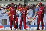 West Indies' captain Darren Sammy, left, celebrates with bowler Kemar Roach, center and Chris Gayle, right, after the dismissal of England batsman Ian Bell during the Cricket World Cup match between England and West Indies in Chennai, India, Thursday, March 17, 2011.