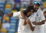 India's bowler Ishant Sharma, left, celebrates with Suresh Raina after taking the wicket of West Indies' Darren Sammy, unseen, on the fifth day of the second cricket Test match in Bridgetown, Barbados, Saturday July 2, 2011.