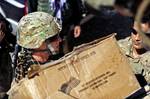 U.S. Army Cpl. Jacob Bath, a Civil Affairs member of Provincial Reconstruction Team Farah, transports care packages during a visit with his Afghan friends at the orphanage in Farah City, Farah province, Afghanistan June 19. Bath and other PRT members are visiting the orphanage to deliver toys and other goods to the children.