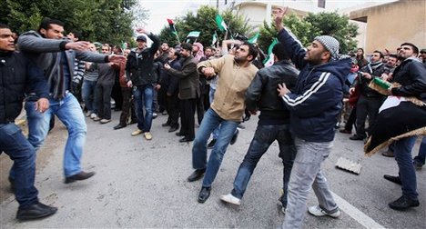 Men chant slogans during an anti-Syrian regime protest in front of the Chinese embassy in Tripoli, Libya, Monday, Feb. 6, 2012. Russia and China have vetoed a U.N. Security Council resolution aimed at ending Syria's bloodshed, despite international outrage over a devastating bombardment of the city of Homs by President Bashar Assad's forces. The veto and the show of support by Russia last Saturday raised concerns that Assad's regime could now unleash even greater violence to crush the revolt against his rule, assured that his ally would prevent international action while continuing its weapons sales to Damascus. (AP Photo/Abdel Magid al-Fergany)