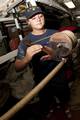 CARIBBEAN OCEAN - Seaman Bryn Barley, stationed aboard the U.S. Coast Guard Cutter Eagle, serves and parcels a craneline, that will be used on the shrouds and backstays Tuesday, June 15, 2010. The process of serving and parceling a craneline is several hours, which includes wrapping Danish marlin around the wire rope groves then applying a layer of sail canvas and baby fat, to create an air tight boundary, that protects the steel. U.S. Coast Guard photo by Petty Officer 2nd Class Jetta H. Disco.