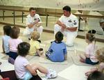 Electrician's Mate 1st Class John Campbell, left, and First Class Machinist Mate Clyde Barley, assigned to Pre-Commissioning Unit George H.W. Bush (CVN 77), speak to children at the Roanoke YMCA about life aboard an aircraft carrier.