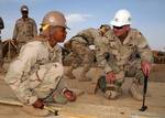 Capt. Jeff Borowy, right, commander of the 25th Navy Construction Regiment speaks with Builder Constructionman Kalani Gaines, assigned to Naval Mobile Construction Battalion (NMCB) 5, at the Barley company prefabrication yard.