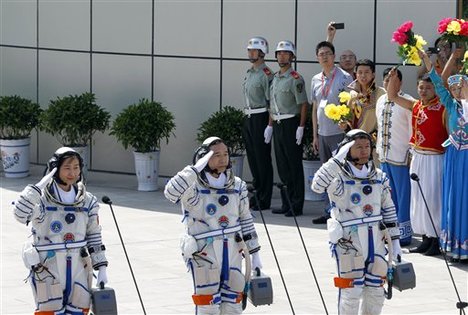 File - China's astronauts from left Liu Yang, Jing Haipeng and Liu Wang salute before they depart for the Shenzhou 9 spacecraft rocket launch pad at the Jiuquan Satellite Launch Center in Jiuquan, China, Saturday, June 16, 2012.