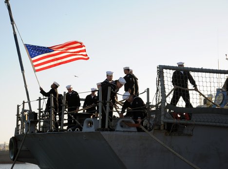 Sailors aboard the USS Samuel B. Roberts hoist the American flag.