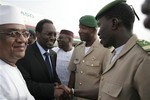 Dioncounda Traore, second left, Mali's parliamentary head who was forced into exile after last month's coup, is greeted by junta representatives including spokesman Lt. Amadou Konare, second right, as Traore arrives at the airport to take up his constitutionally-mandated post as interim president, in Bamako, Mali Saturday, April 7, 2012.