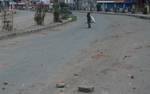 A boy carry bag on his shoulder on deserted street during a Undecleared curfew in Srinagar on 26, June 2012. Life across Kashmir was disrupted due to a strike called by separatists over gutting of the over 300-year-old Dastageer Sahib sufi shrine in Khanyar area of the city.