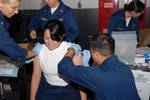 Boatswain's Mate Seaman Maria Orcillo receives both the anthrax and smallpox vaccines simultaneously aboard the aircraft carrier USS Ronald Reagan (CVN 76).