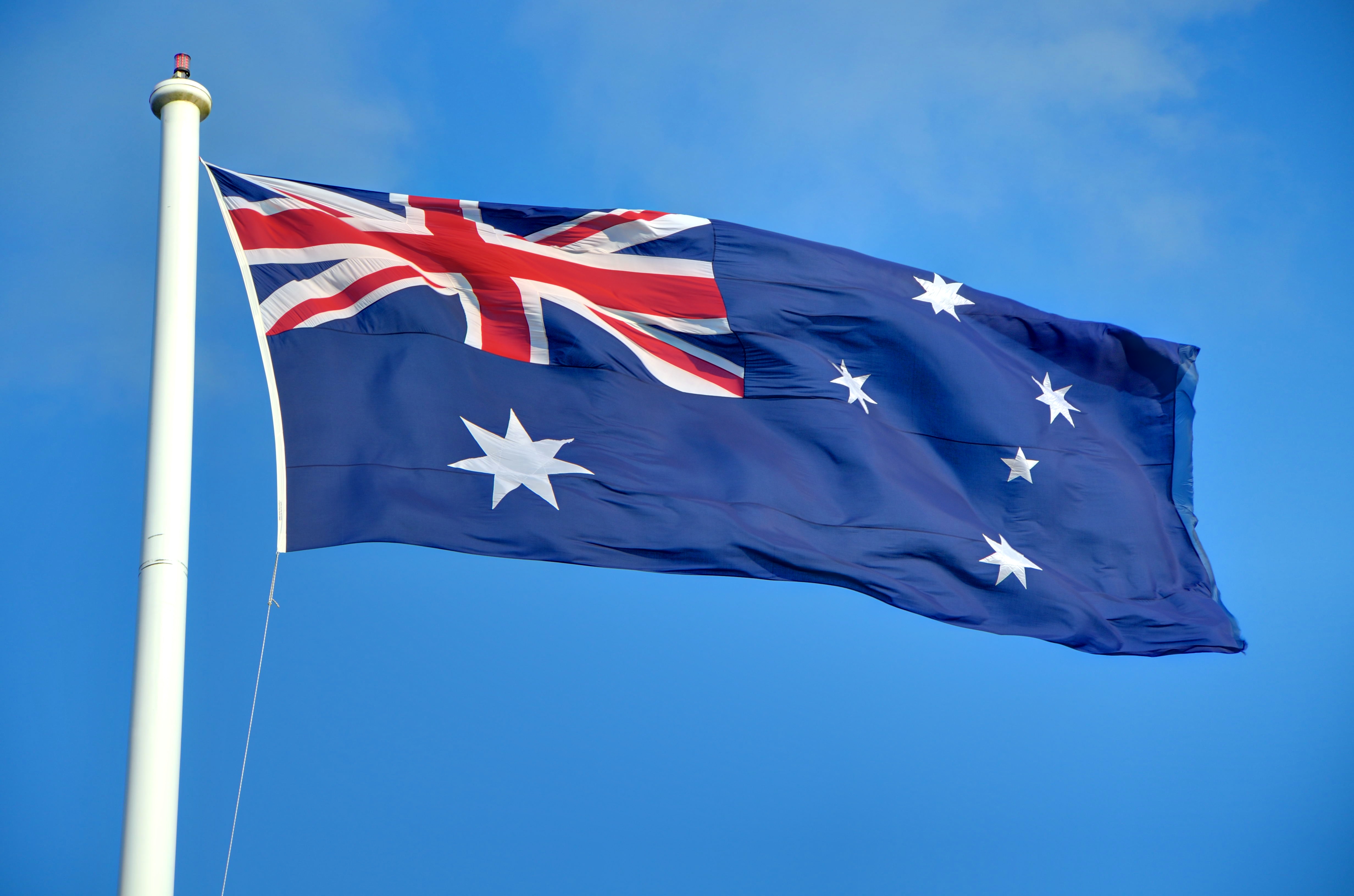 A large Australian flag flying against the blue sky.