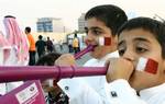 Qatari boys with their faces painted in the colours of their national flag, blow vuvuzelas, at Doha's traditional souk where people gathered to follow FIFA's selection on the two countries to host the World Cups, 2018 and 2022, in Doha, Qatar, Thursday, Dec. 2, 2010.