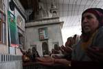 Kashmiri Muslim women pray outside the shrine of Sufi saint Hazrat Sheikh Hamza Makhdoom, commonly known as Sultan-Ul-Arifeen, during the saint's Urs, or yearly commemoration, in Srinagar, the summer capital of Kashmir, 29 January 2011. Thousands of Kashmiri Muslims who believe in Sufism thronged the shrine to offer prayers.