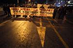 Members of the Greek Communist party-backed PAME union hold a banner that reads 