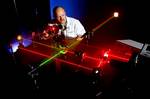 Daniel King prepares alignment of various optical components using eye-safe visible lasers.