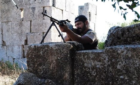 This citizen journalism image provided by Shaam News Network SNN, taken on Monday, July 4, 2012, purports to show a Free Syrian Army soldier aiming his weapon in the northern town of Sarmada, in Idlib province, Syria.