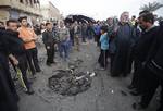 People inspect a crater caused by a car bomb attack Baghdad, Iraq, Thursday, Jan. 27, 2011. A car bomb ripped through a funeral tent in a mainly Shiite area of Baghdad on Thursday, killing and wounding scores of people and prompting scuffles between police and Iraqis angry about security failures.