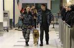 Police officers with a sniffer dog walk after an explosion at Domodedovo airport in Moscow, Monday, Jan. 24, 2011. An explosion ripped through the arrivals hall at Moscow's busiest airport on Monday, killing many people. The Russian president called it a terror attack.