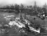 Aerial view of USS ARIZONA on the East River in New York City near the Brooklyn Bridge on its way to sea trials. 1918.