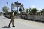 Indian paramilitary troops stand guard outside at Matyers Grave Yard in down town Srinagar, India, on Sunday 17, June 2012. To foil the Eidgah chalo march called by the Chairman of breakaway Hurriyat Conference Syed ali Shah Geelhi to offered Fetha to all those who were killed during 2008 and 2010.