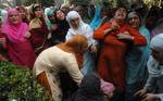 Kashmiri Muslim relatives of ruling party National Conference Block President Abdul Rehman Ganaie mourn during his funeral in Srinagar on June 15,2012. Suspected Muslim rebels gunned down Ganaie in the latest string of alleged political killings in Kashmir. Ganaie was shot at close range by suspected rebels as he was leaving his home to offer Friday prayers at a local mosque,police said