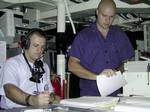 Arabian Gulf (July 15)--RD3 Jason V. Slaughter (right) logs aircraft communications, while FT3 Robert 