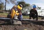 Equipment Operator 2nd Class Michael McAfee cuts segments of pipe for a fence.