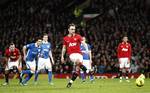 Manchester United's Dimitar Berbatov, centre, scores a penalty for his third goal against Wigan during their English Premier League soccer match at Old Trafford Stadium, Manchester, England, Monday Dec. 26, 2011.