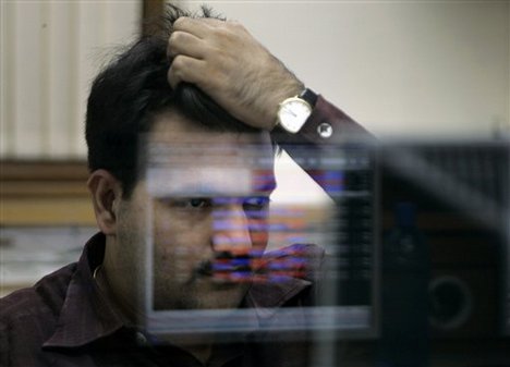 A broker reacts while trading in a brokerage firm in Mumbai, India, Tuesday, Nov. 11, 2008. India's benchmark Sensex stock index dived 5.3 percent Tuesday as hopes faded that China's $586 billion stimulus package will rescue the world economy and on news that some of India's largest companies are cutting back projects.