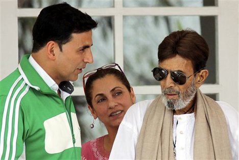 In this photo taken June 20, 2012, Indian Bollywood star Rajesh Khanna, right, speaks with son-in-law and Bollywood actor Akshay Kumar, left, as his wife actress Dimple Kapadia looks on in Mumbai, India.