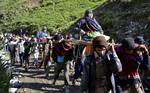 A Hindu devotee is carried by porters during their pilgrimage at Domal 120 kms from Srinagar on 08, July 2012. To the holy Amarnath Cave Shrine over 2.70 lakh pilgrims paid obeisance at the 3,857 meters high cave shrine so far.